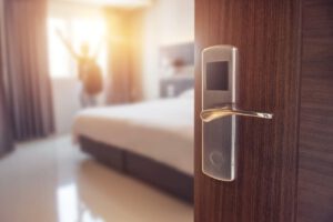 close shot of a silver hotel door handle with the hotel room in the background
