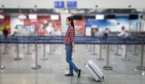 women walking through airport with face mask on
