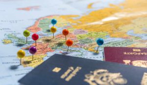 colorful pins in world map next to two passports