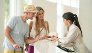 young couple checking in at reception desk in hotel