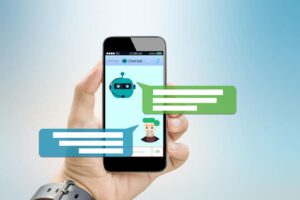 a hand holding a smartphone showing a text conversation with a chat bot and two message bubbles