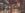 blurred image of a restaurant with exposed brick, black and white chairs, wood flooring, and tiles on the floor